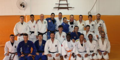 Equipe de judô em pose parafoto debaixo de um simbolo japonês